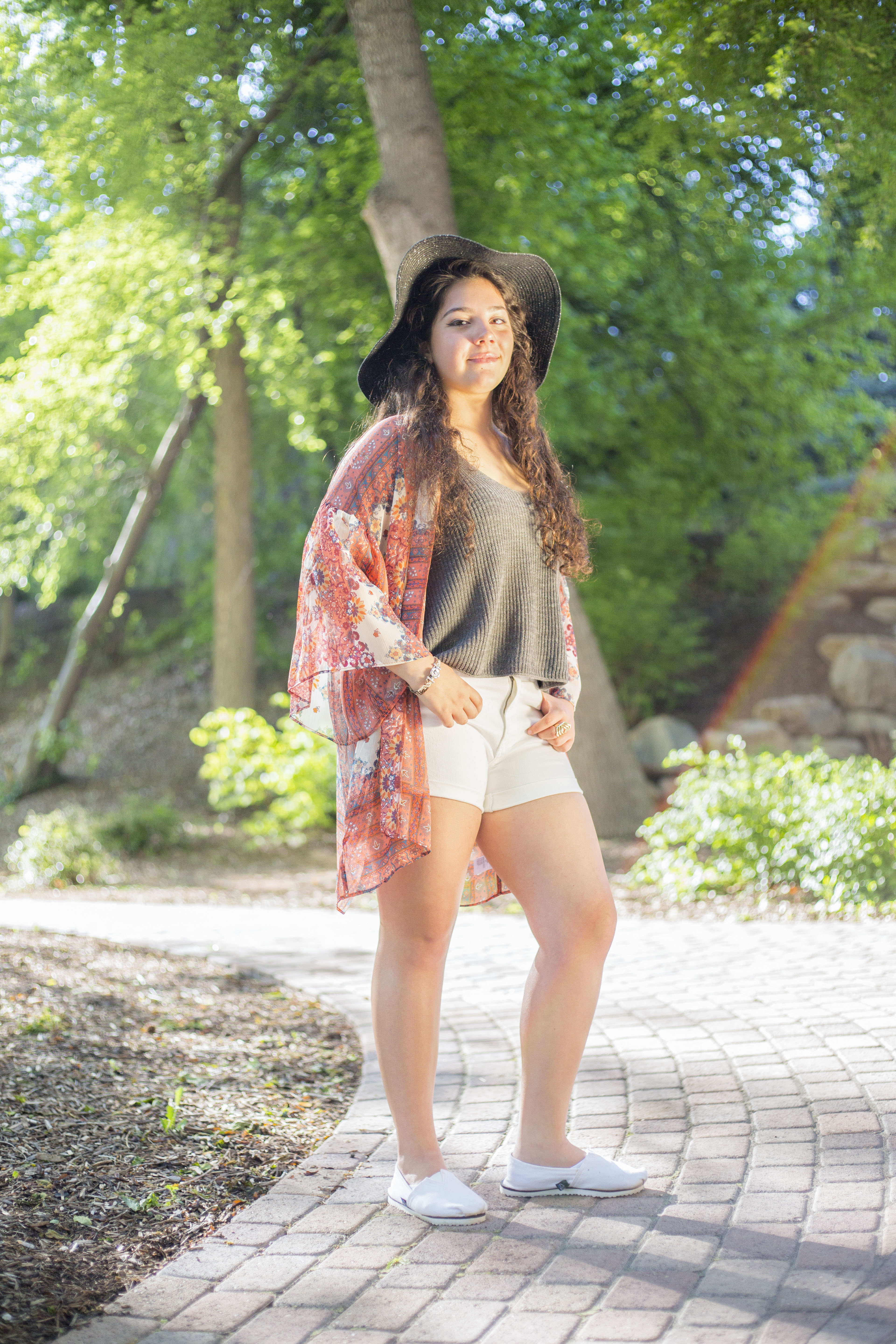 A young woman on a brick path at BYU campus for her quinceañera photos.