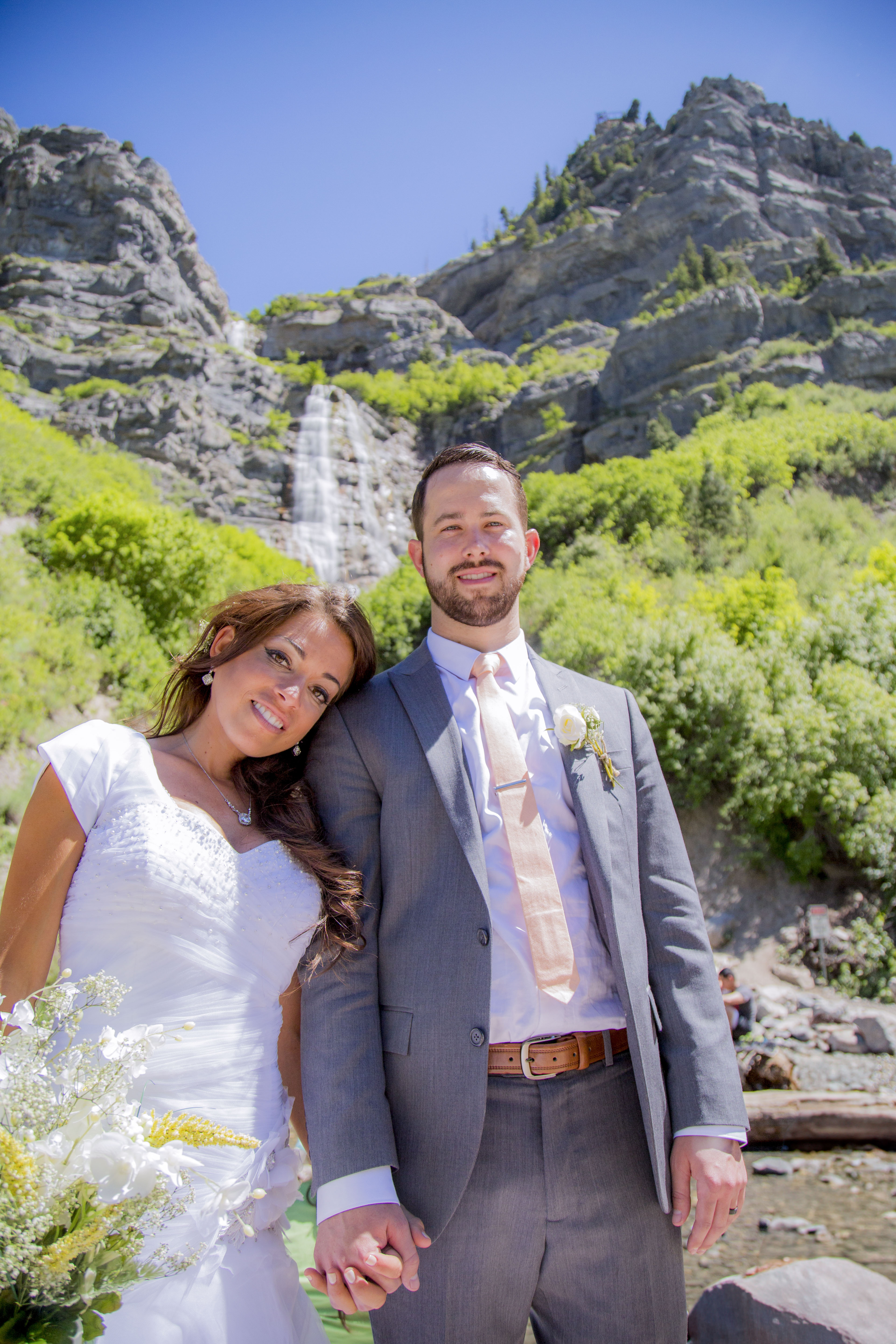 A newly married couple poses for a wedding photo in front of Bridal Veil Falls in Provo Canyon.