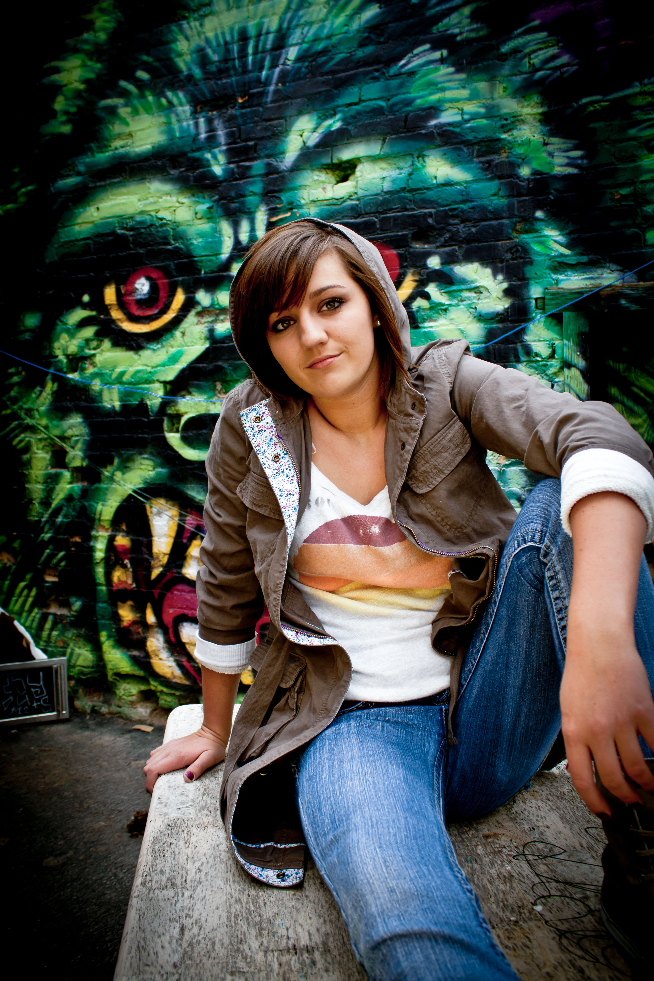A high school senior with an urban, gritty background featuring a graffiti mural in Salt Lake City.