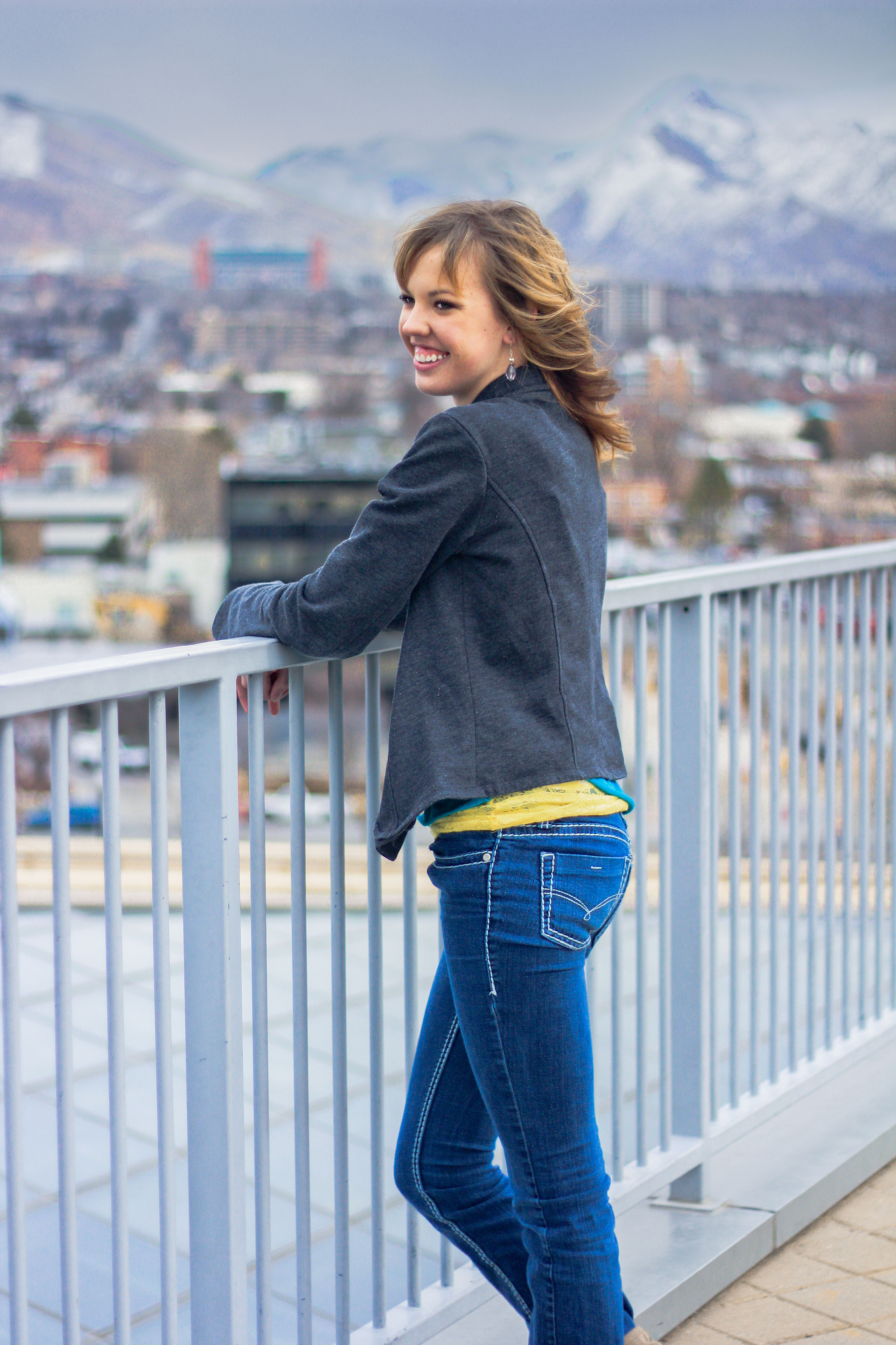 A high school senior portrait overlooking the Salt Lake City skyline with mountains in the background.