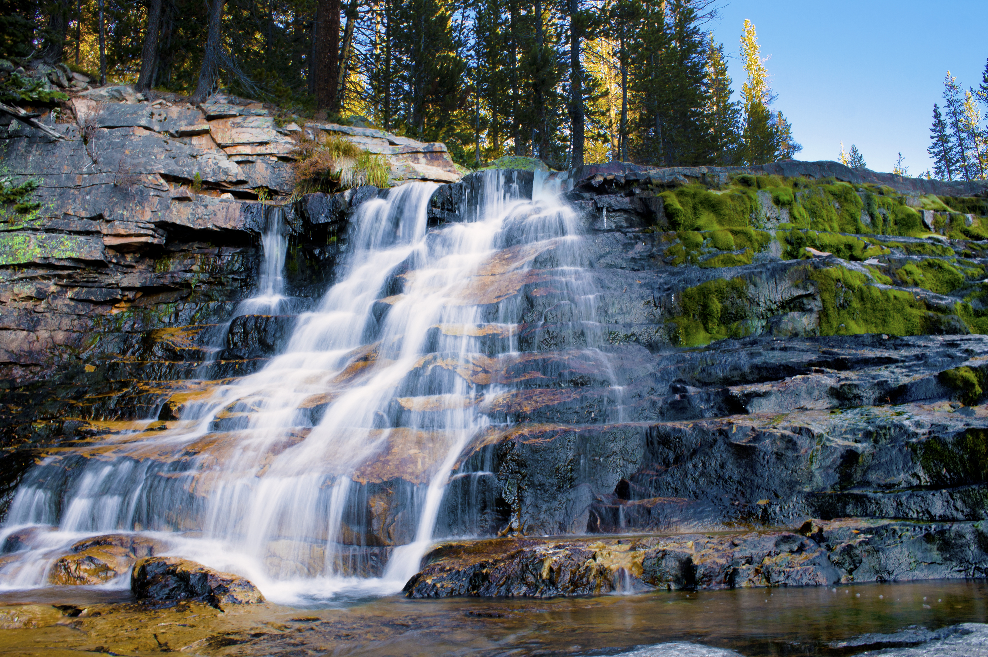 Long exposure shot of a cascading waterfall over mossy rocks.