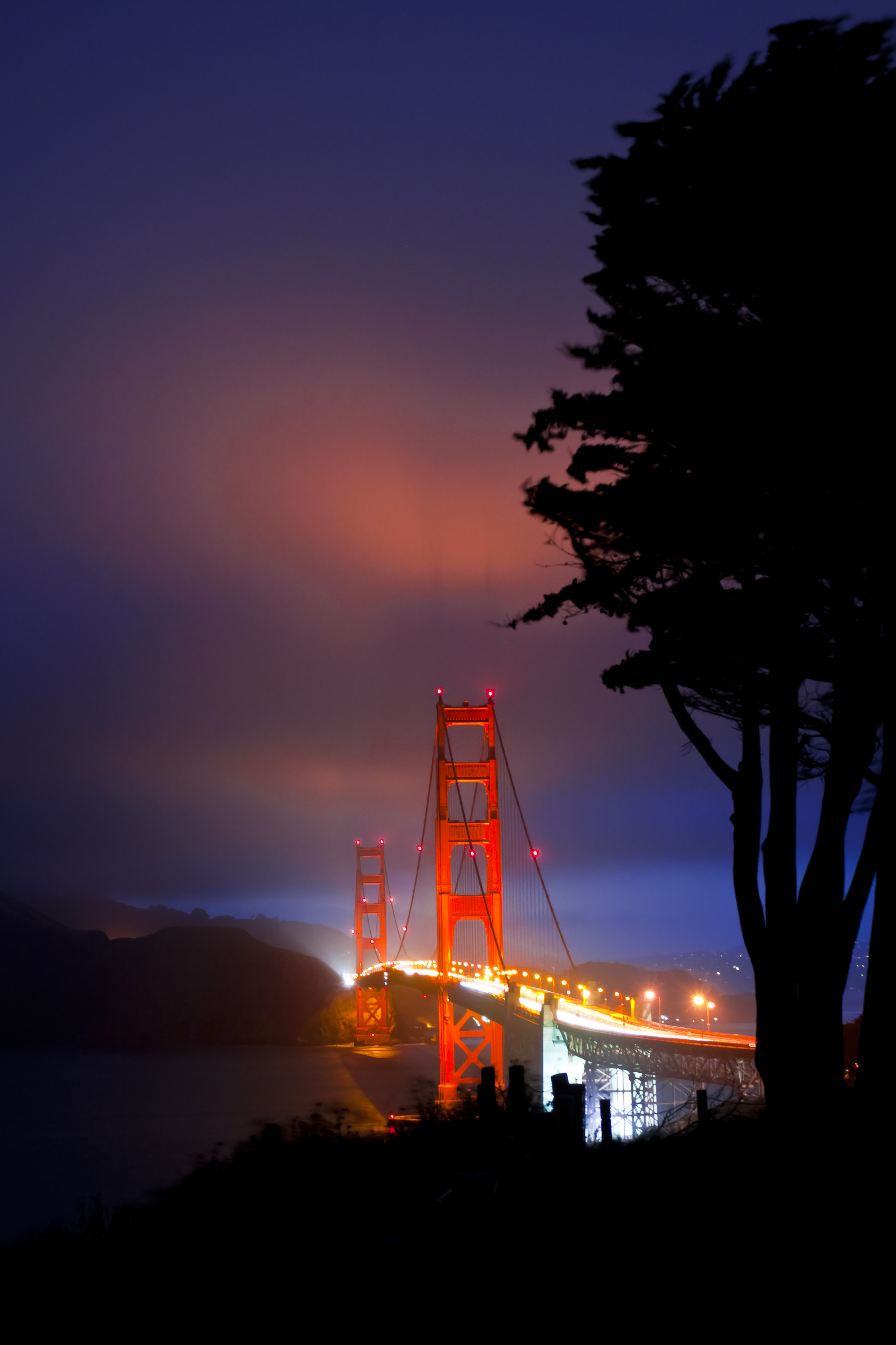 Night photography of the Golden Gate Bridge in San Francisco with long exposure light trails.