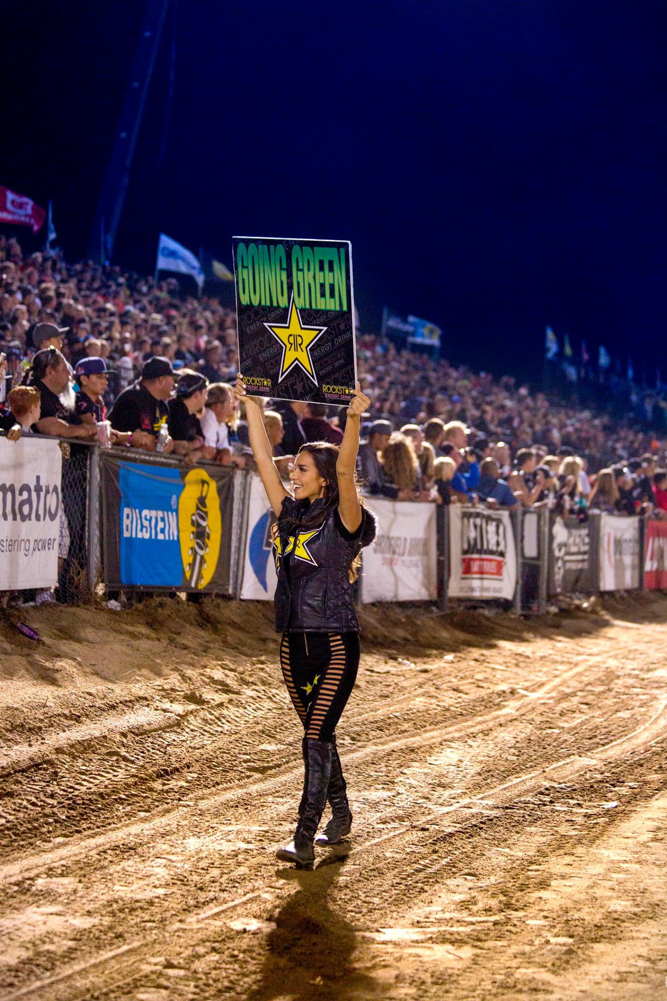 A green and black race buggy in motion during a motorsports event.