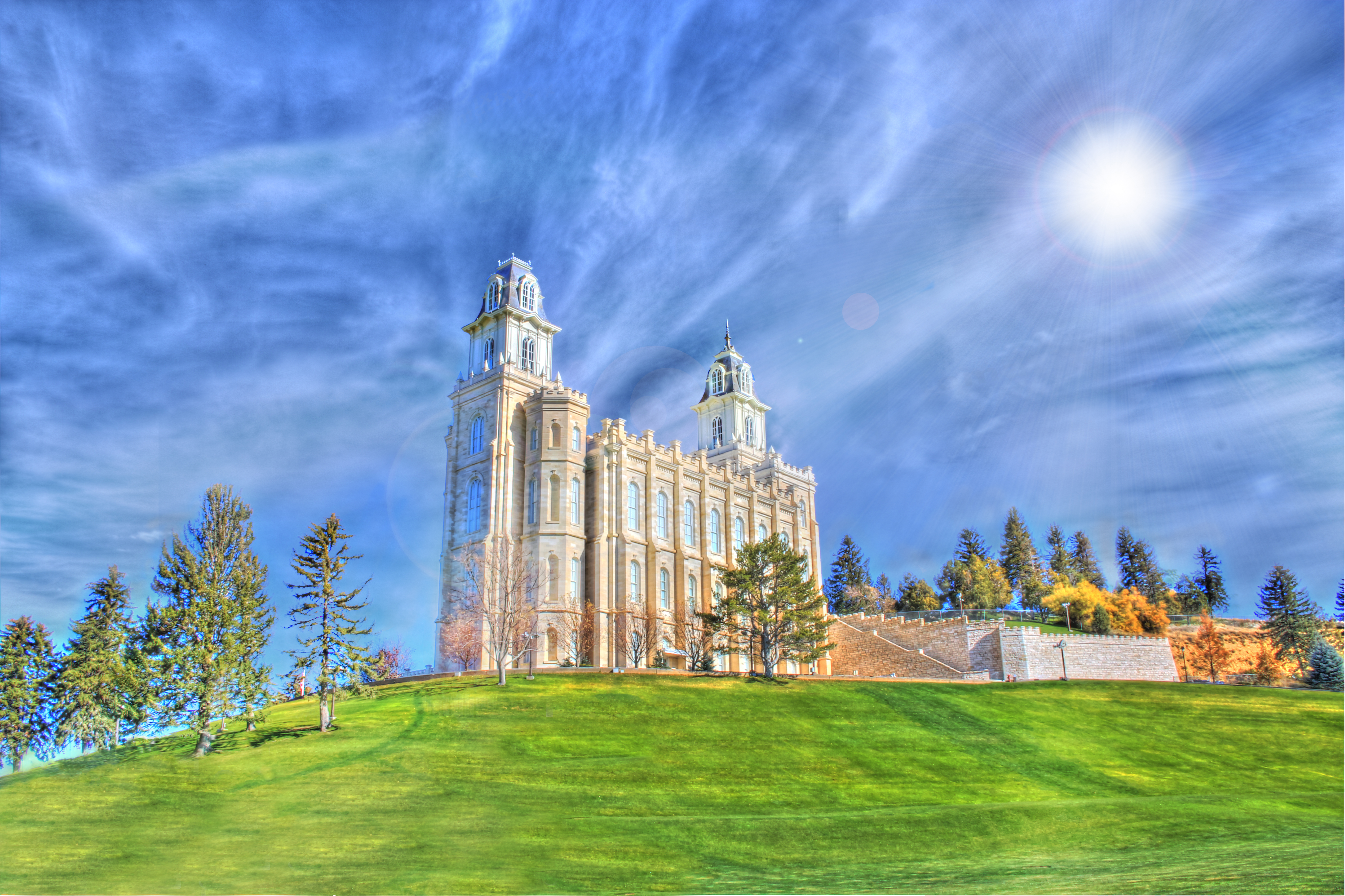 The Payson Utah LDS Temple standing on a hill against a blue sky.