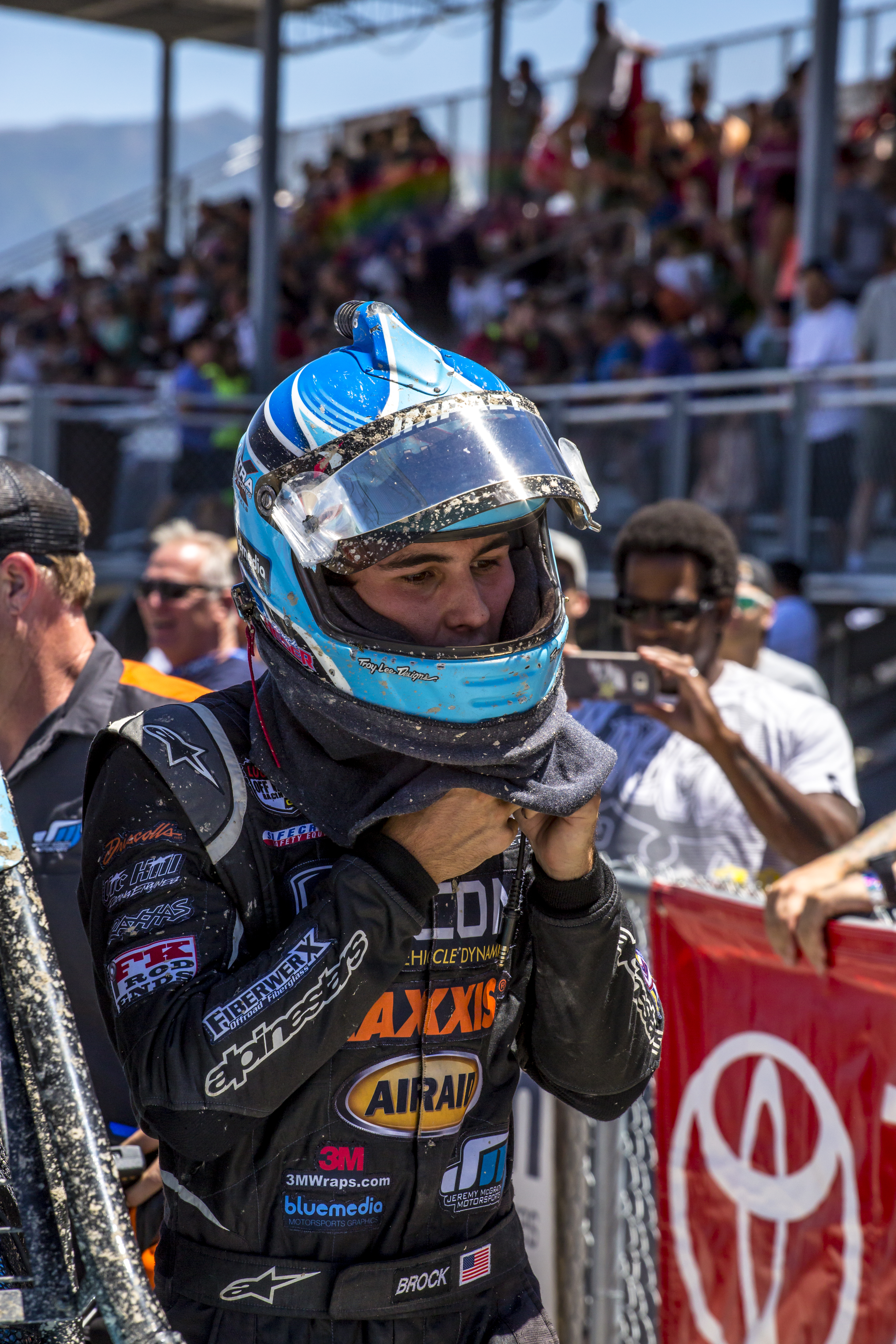A race driver celebrating a win on the roof of his truck.